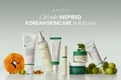 Axis-Y Korean skincare products arranged with papaya, green grapes and leaves on a pale green background