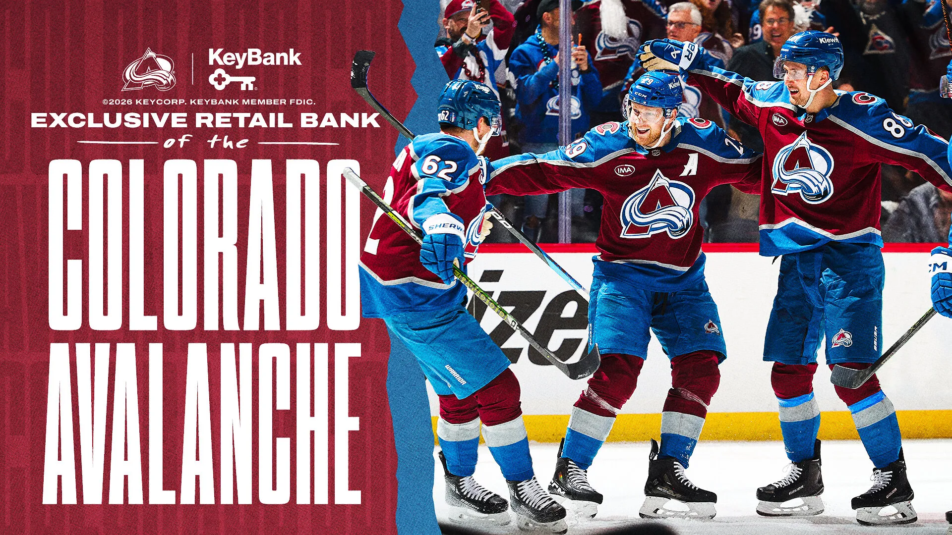 Colorado Avalanche players celebrate beside a KeyBank advertisement.