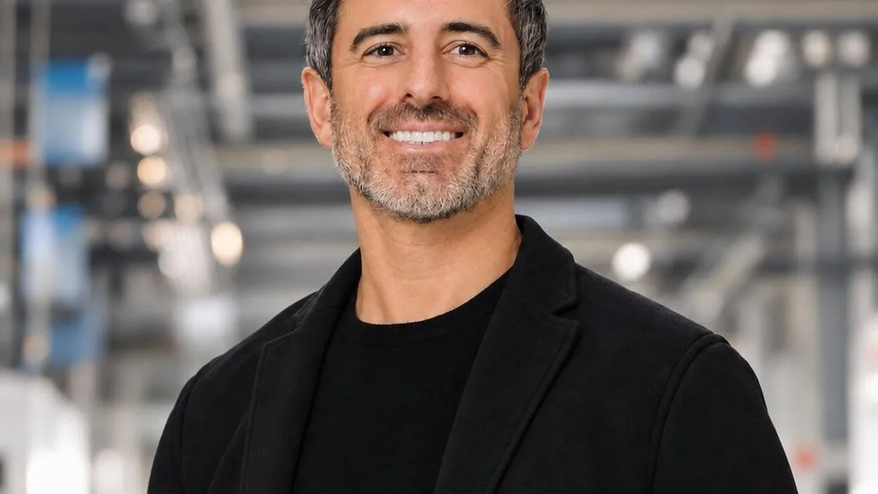Ali Torabi in a black jacket standing in an industrial facility.