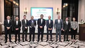 Nine people stand at an LNG sale and purchase agreement signing ceremony.