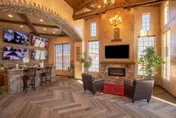 A warm lobby with armchairs, fireplace, wall-mounted television and security monitors