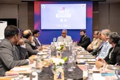 Business leaders seated around a conference table beneath a screen reading “Think GCC Think U.P.”