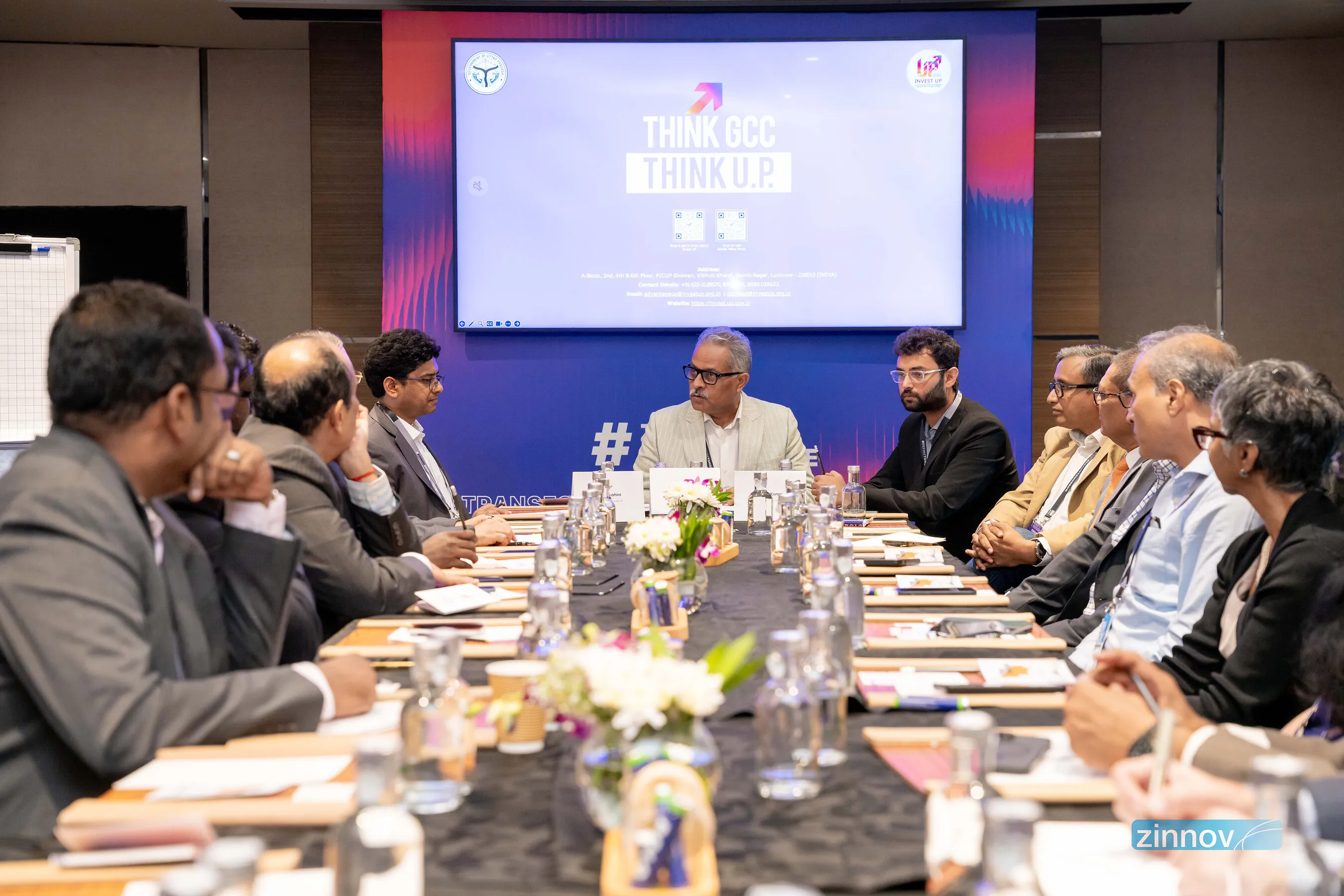 Business leaders seated around a conference table beneath a screen reading “Think GCC Think U.P.”
