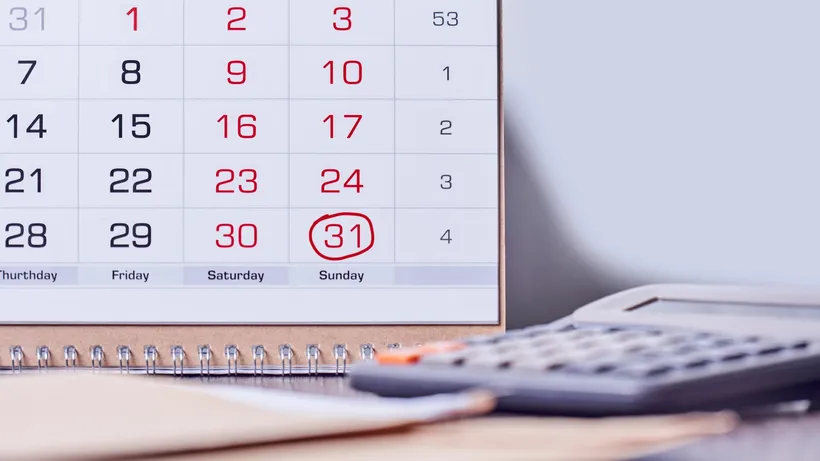 Calendar with a red-circled date beside a calculator and paperwork.